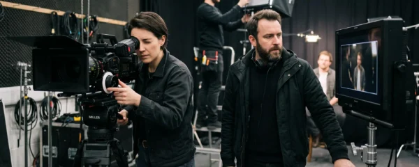 Équipe de production vidéo professionnelle en plein tournage avec caméra cinéma, moniteur de contrôle et panneaux d'éclairage LED sur un plateau
